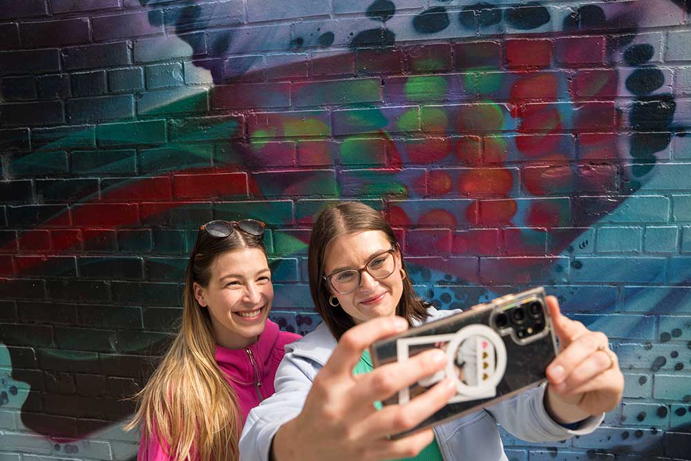 2 women taking a selfie at a mural
