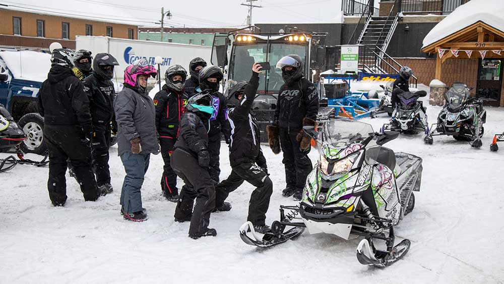 group of snowmobilers taking selfie