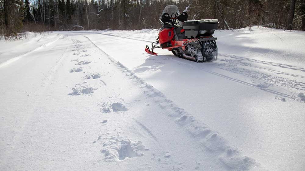 snowmobile on trail with animal tracks