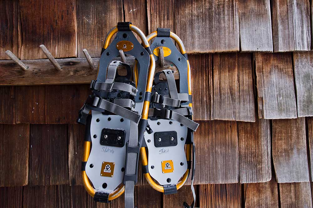 snowshoes leaning against cedar shingles